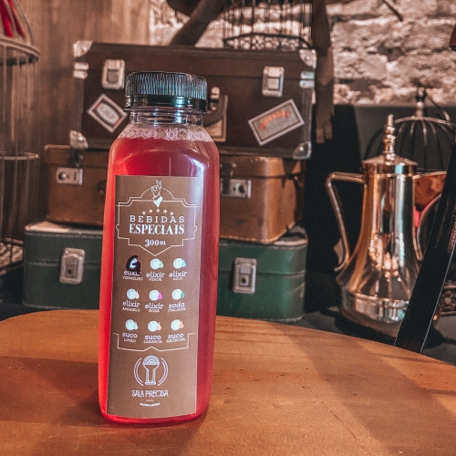 Garrafa com líquido vermelho e rótulo marrom