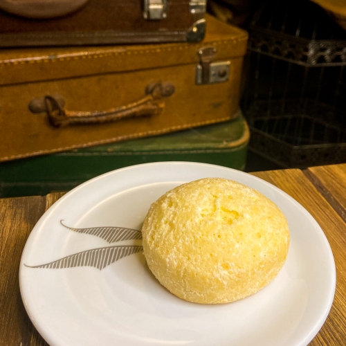 Pão de queijo sobre um prato branco com asas desenhadas