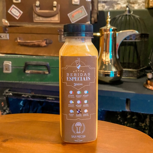 Garrafa com líquido laranja e rótulo marrom