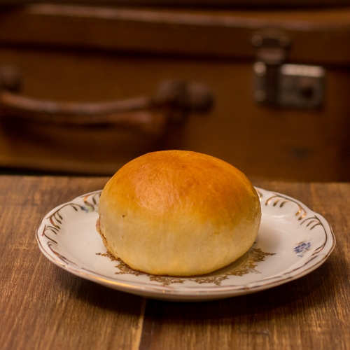 Um prato com um pão de batata dourado