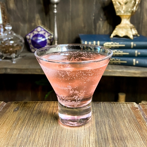 Uma taça transparente com líquido rosa
