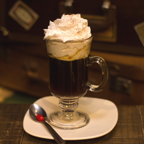 Uma caneca transparente com café e chantilly por cima