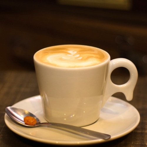 Uma xícara branca com café e leite